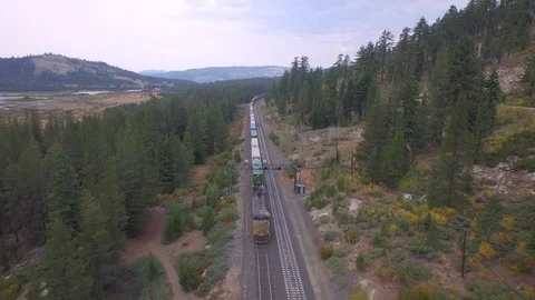 Aerial drone view, cargo freight shipping train on mountain forest railway Stock Footage 100861898