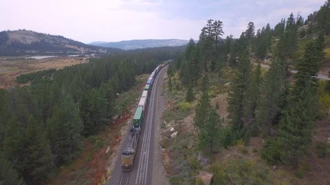 Aerial drone view, cargo freight shipping train on mountain forest railway Stock Footage 100861913