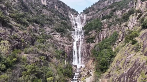 Aerial drone view of cascading waterfall Tiantai Mountain flowing over multiple Stock Footage 336563655