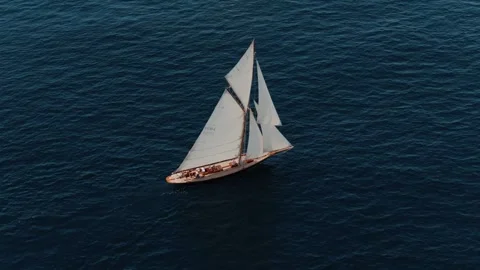 Aerial drone view of a classic sailing yacht cruising across deep blue open sea Stock Footage 345293060