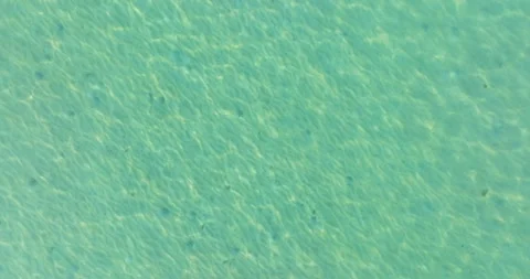 Aerial drone view of clear turquoise sea and waves over the rocky coastline Stock Footage 280821063