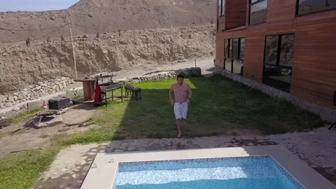Aerial drone view closeup of a man jumping into the pool with friends at the swi Vídeos de archivo 199633935