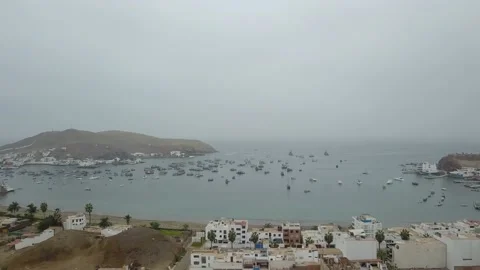 Aerial drone view of a cloudy beach with many boats close to shore in 4K at Stock Footage 155799798