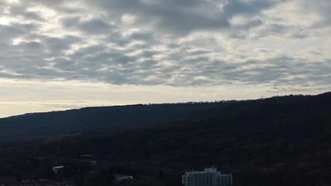 Aerial drone view of cloudy sky above distant dark landscape Stock Footage 322902019