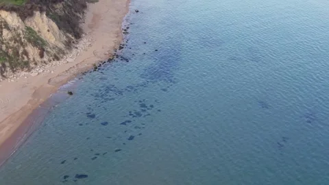 Aerial drone view of coastal cliffs, sandy beach and clear sea Stock Footage 322902111