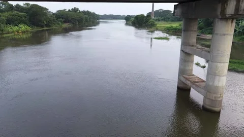 Aerial drone view of a concrete bridge over a wide river in a village Stock Footage 341521323