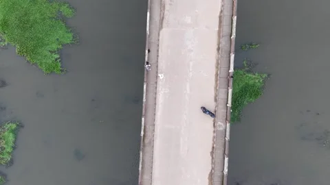 Aerial drone view of a concrete bridge over a wide river in a village Stock Footage 341521446