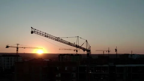 Aerial Drone view of Construction Cranes in Sunset Light. Construction Site Stock Footage 134995648