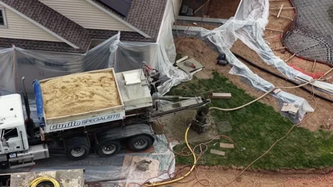 Aerial drone view of construction crew building backyard swimming pool, gunite Stock Footage 333330312