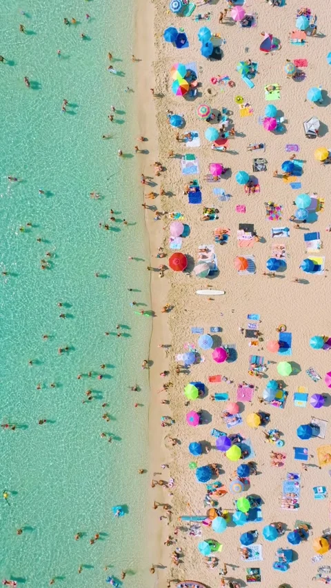 Aerial drone view of a crowded beach with umbrellas and people relaxing. Stock Footage 337344763