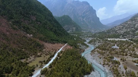 Aerial drone view of crystal-clear waters flowing through a rugged Himalayan Stock Footage 311018854