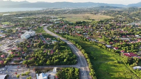 Aerial Drone View of Curving Road Through Tropical Town Landscape Stock Footage 332974739