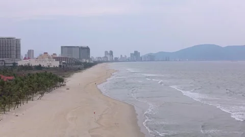 Aerial drone view of Da Nang coastline with sandy beach and distant city skyline Stock Footage 339226660