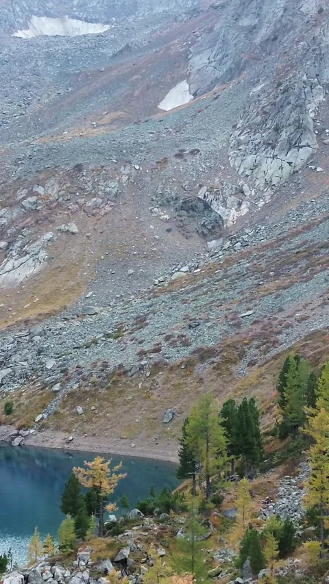 Aerial Drone View of a Deep Blue Alpine Lake and Rocky Mountain Waterfall Video stock 347897406