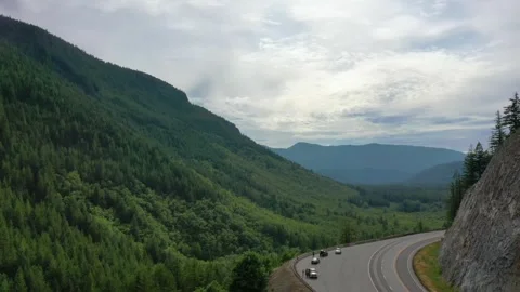 Aerial Drone view of dense forest in Mount Hood as a car drives thru the pass Stock Footage 312531706