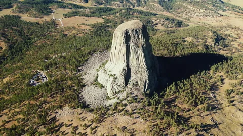 Aerial drone view of Devils Tower National Monument rising dramatically above Stock Footage 330801411