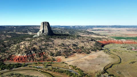 Aerial drone view of Devils Tower National Monument rising dramatically above Stock Footage 330801632