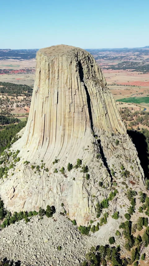 Aerial drone view of Devils Tower National Monument rising dramatically above Stock Footage 332366534