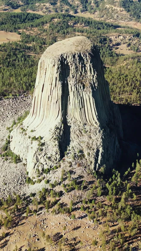 Aerial drone view of Devils Tower National Monument rising dramatically above Stock Footage 332367115