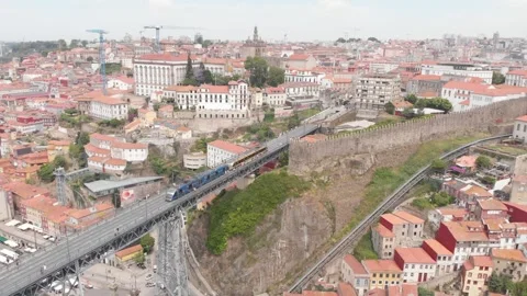 Aerial: Drone view of Dom Luis I Bridge with tram crossing and historic center 動画素材 345109490