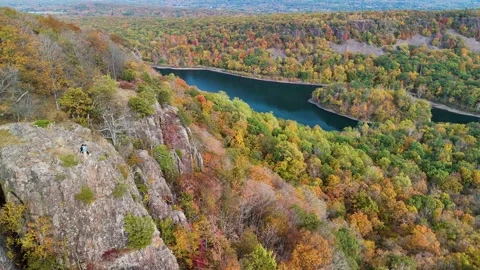 Aerial drone view of dramatic cliffs, vibrant fall forest foliage, and... Stock Footage 319883550