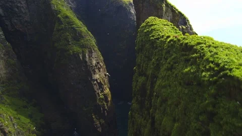 Aerial drone view of dramatic mossy sea cliffs and narrow ocean gorge in summer. Stockbeeldmateriaal 342430325
