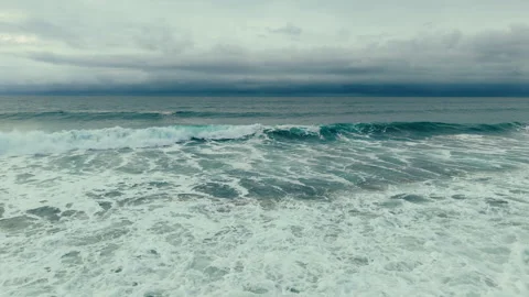Aerial drone view of dramatic ocean waves under cloudy skies at Pacific Beach Video stock 339252633
