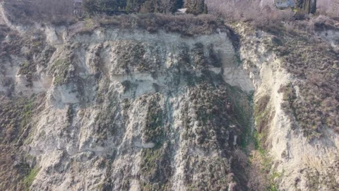 Aerial drone view of dramatic rocky cliff landscape with sparse trees Video stock 330288599