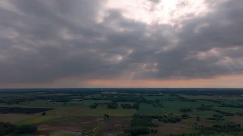 Aerial drone view of dramatic storm clouds over rural farmland at sunset Stock Footage 341784665