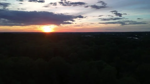 Aerial drone view of dramatic sunset over lush green forest horizon Vidéo 336516256