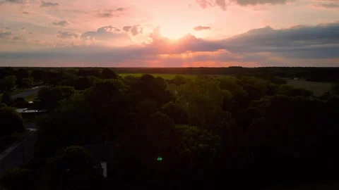 Aerial drone view of dramatic sunset over lush green forest horizon Stock Footage 336516265