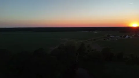 Aerial drone view of dramatic sunset over lush green forest horizon Stock Footage 336516266