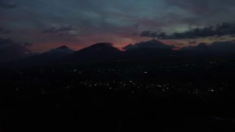 Aerial drone view of dramatic sunset twilight over mountains silhouettes and tow Stock Footage 343144860