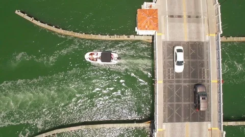 Aerial drone view of draw bridge road with car, boat and jetski traffic Stock Footage 100865860