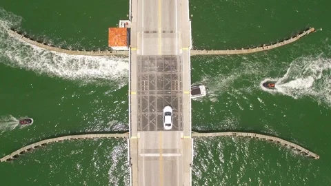 Aerial drone view of draw bridge road with car, boat and jetski traffic Stock Footage 100865878