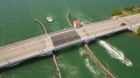 Aerial drone view of draw bridge road with car, boat and jetski traffic Stock Footage 100882957