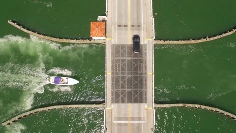 Aerial drone view of draw bridge road with car, boat and jetski traffic Stock Footage 100883082
