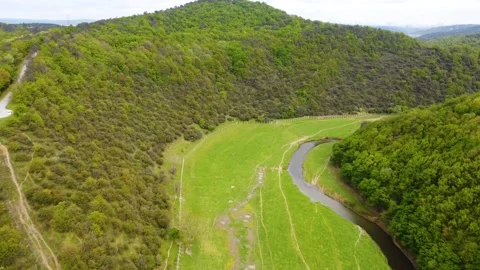 Aerial Drone View of Dried Riverbed Winding Through Lush Green Valley Forest Stock Footage 328641428