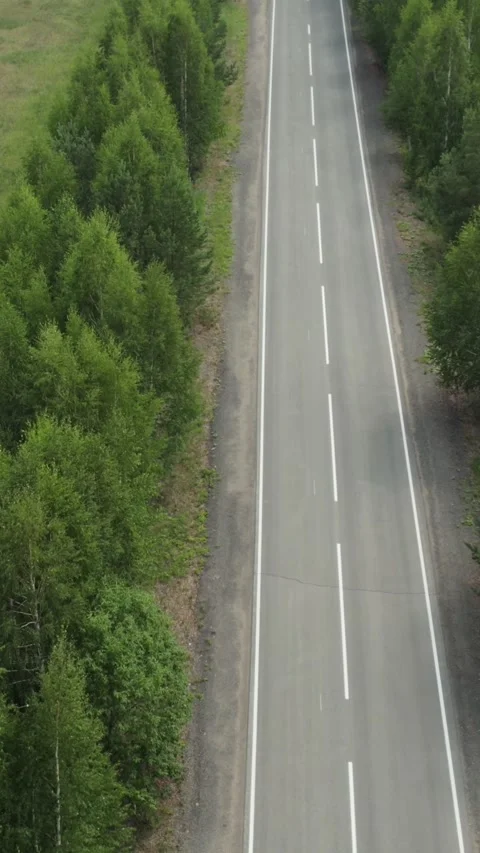 Aerial drone view of empty forest highway cutting through Ural Mountains Russia Video stock 346558694