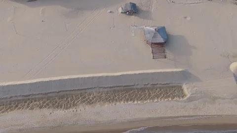 Aerial drone view of empty sandy beach with abandoned wooden huts Stock Footage 322537230
