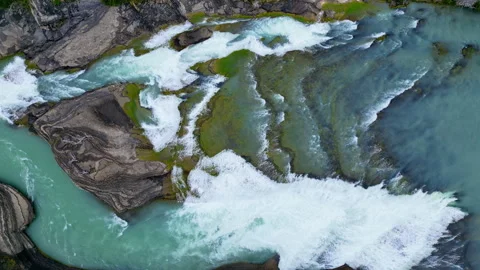 Aerial drone view of fast flowing glacial river cutting through rocky terrain, Stock Footage 321859080