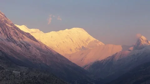 Aerial drone view of the first golden light gently kissing the snow-covered Stock Footage 311019075