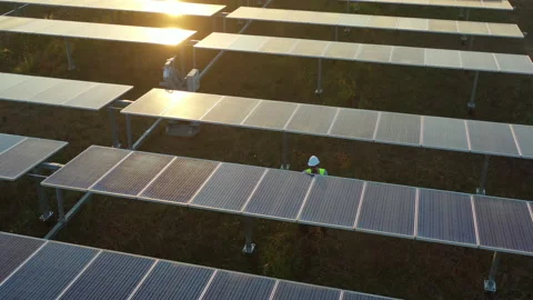 Aerial drone view, Flight over solar panel farm, young engineer wearing helmet Stock Footage 198137669