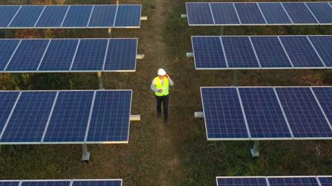 Aerial drone view, Flight over solar panel farm and young engineer wearing  Stock-Footage 198139524