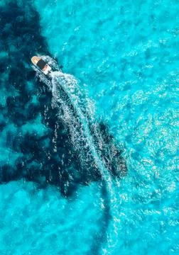 Aerial drone view of floating speed boat in blue sea on sunny day Stock Photos