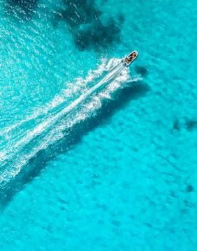Aerial drone view of floating speed boat in blue sea on sunny day Stock Photos
