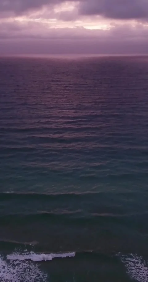 Aerial drone view flying backward over a tranquil sea with gentle waves Stock Footage 344820693