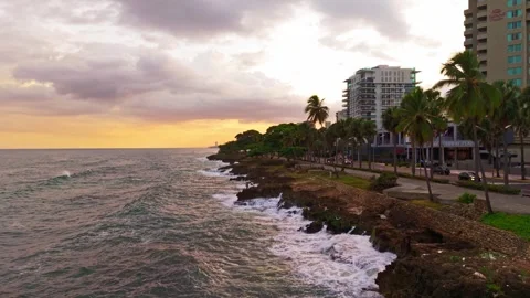 Aerial Drone View Flying Forward over Santo Domingo Malecon Shoreline at Sunset Видео 345028228