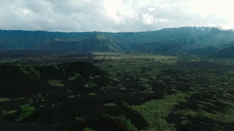 Aerial drone view flying low over solidified black volcanic lava Mount Batur Stock Footage 276864052