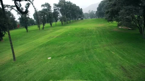 Aerial drone view flying over a lush green golf course fairway and tee box 스톡 동영상 332876976